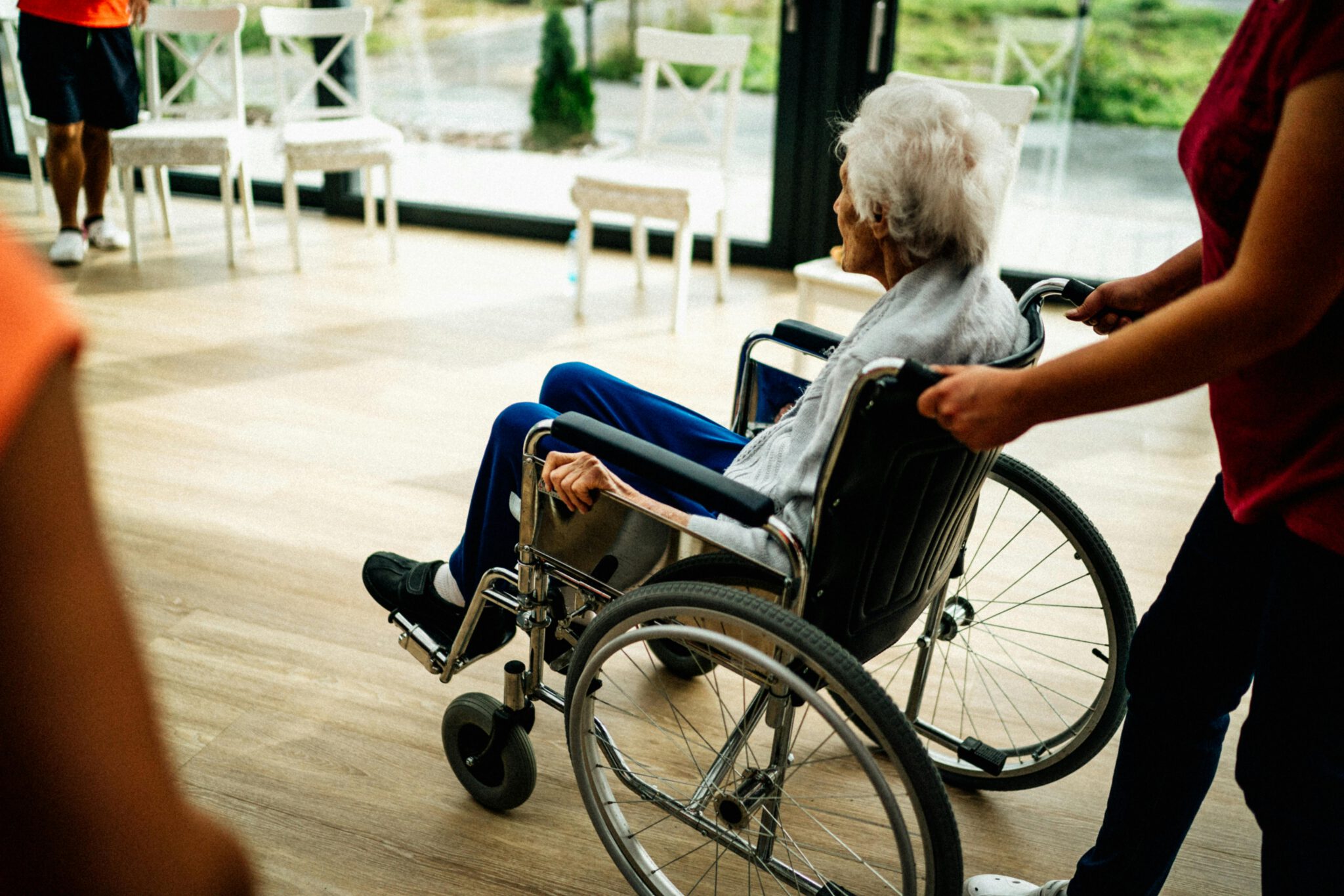 stundenweise Seniorenbetreuung zu Hause Betreuungskraft hält die Hand der pflegebedürftigen Person liebevoll